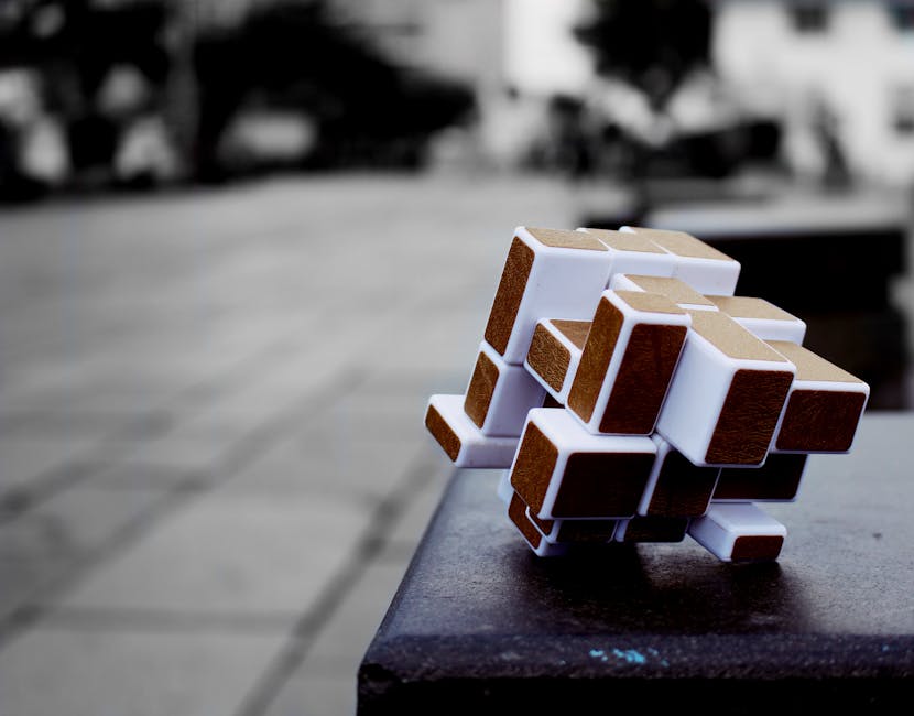 Artistic cube puzzle placed on a surface in an urban setting, capturing depth and focus.