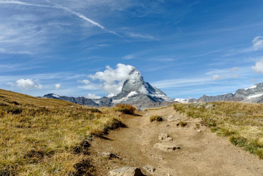 Iconic Matterhorn mountain in Switzerland with a rocky trail under a clear blue sky.