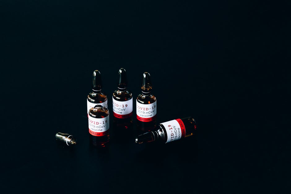 Close-up of COVID-19 vaccine vials on dark surface reflecting modern healthcare challenges.