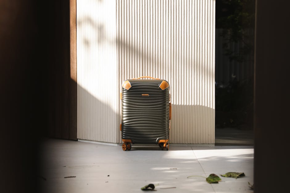 Stylish suitcase in an urban environment, highlighted by natural shadows and light.