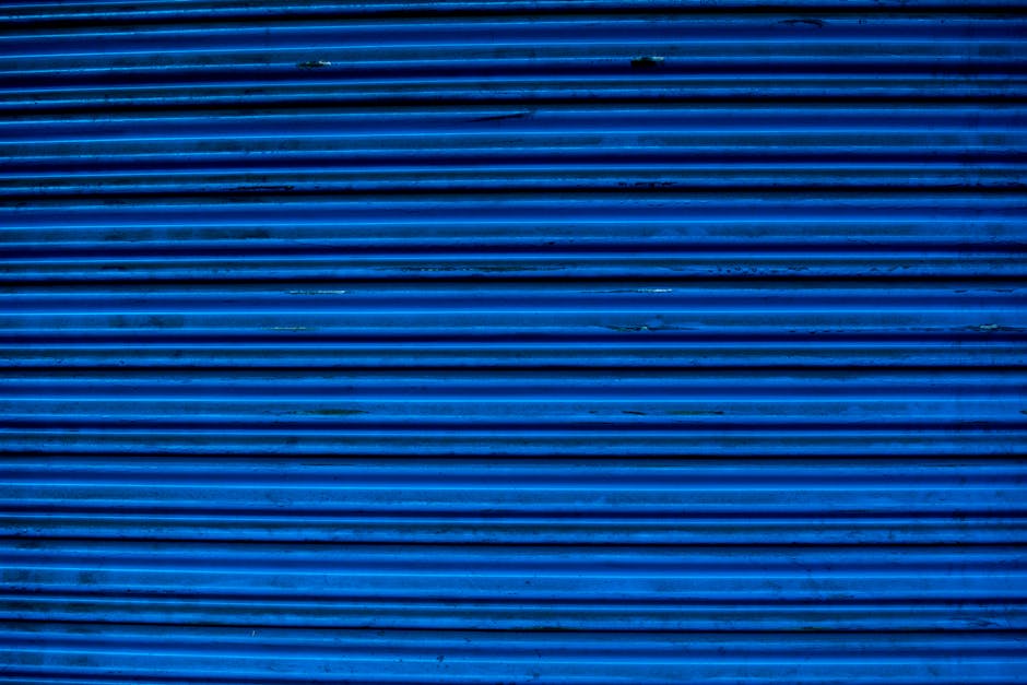 Close-up of a textured blue metal surface showing horizontal lines and patterns, ideal for backgrounds.