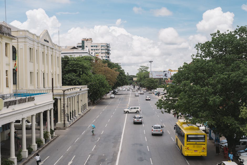High angle view of a bustling street in Yangon with traffic and colonial architecture under a clear sky.